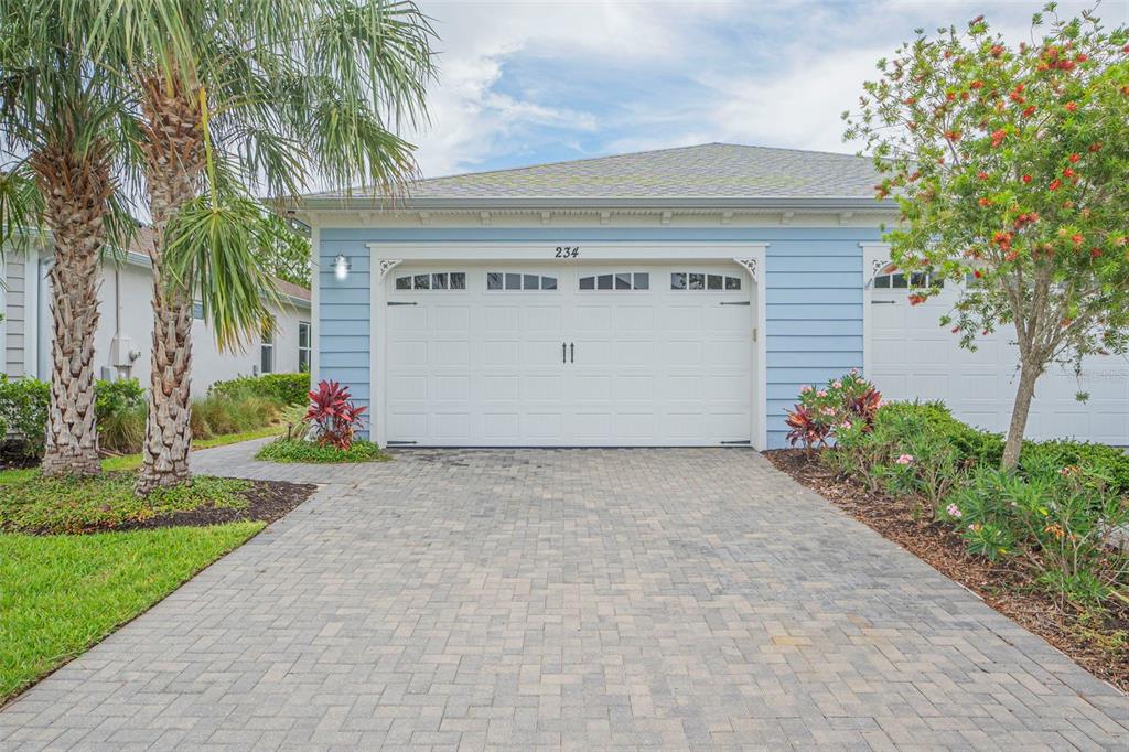 a view of a house with a yard and palm trees