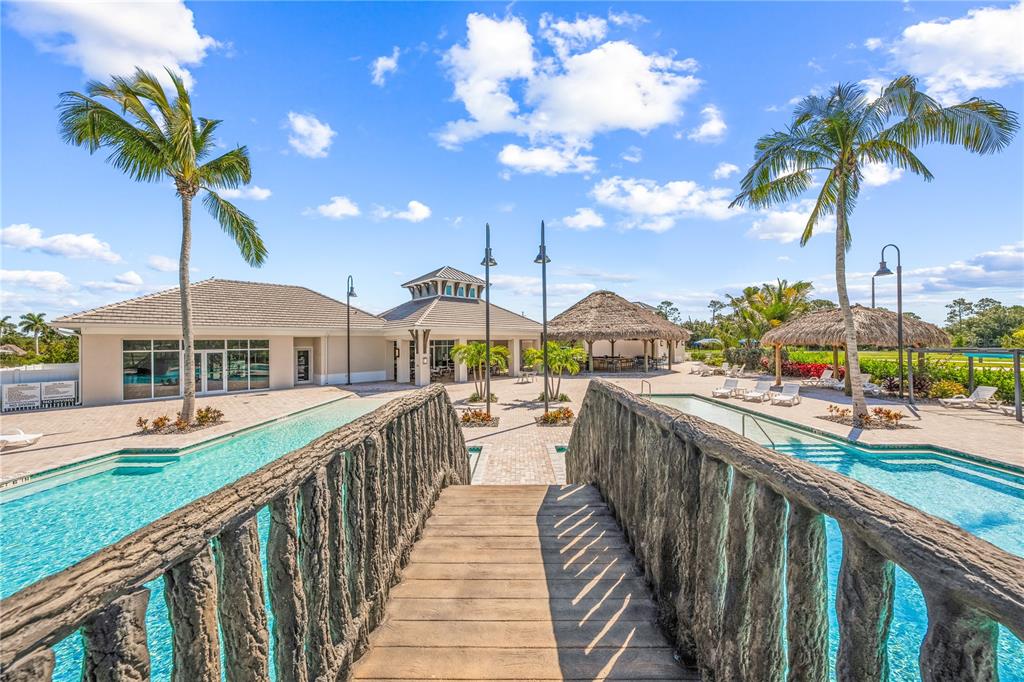 Bridge view over resort pool with view of tiki bar and clubhouse