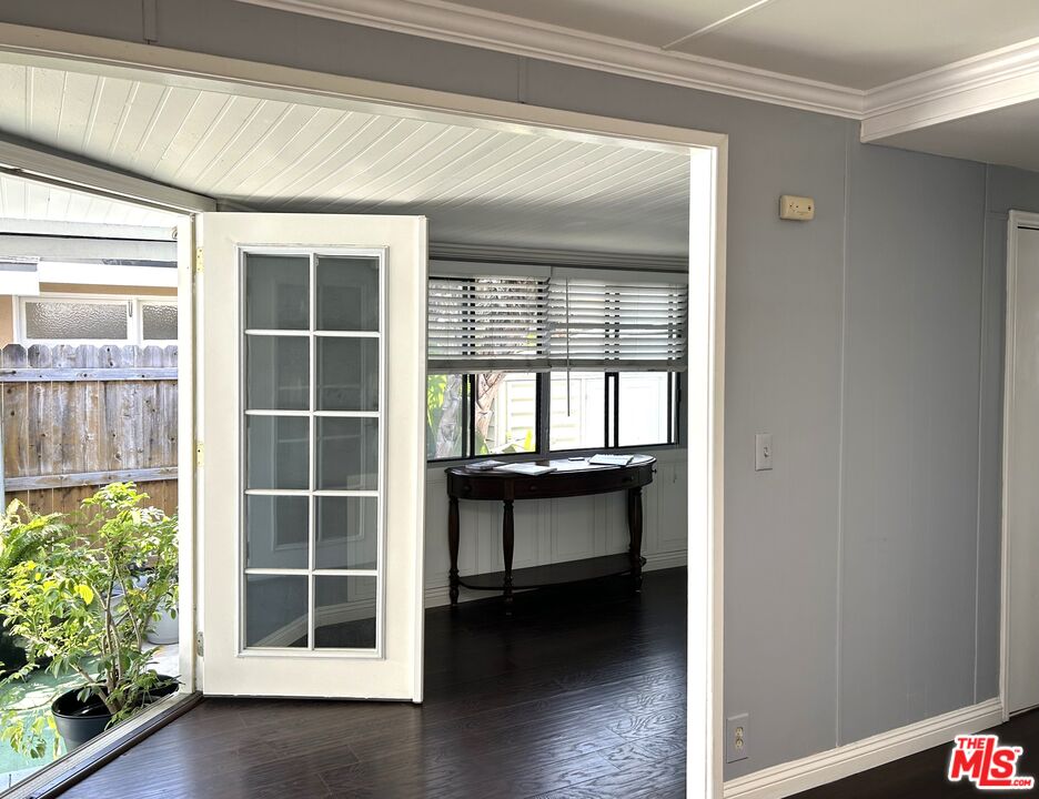 a view of empty room with wooden floor and floor to ceiling window