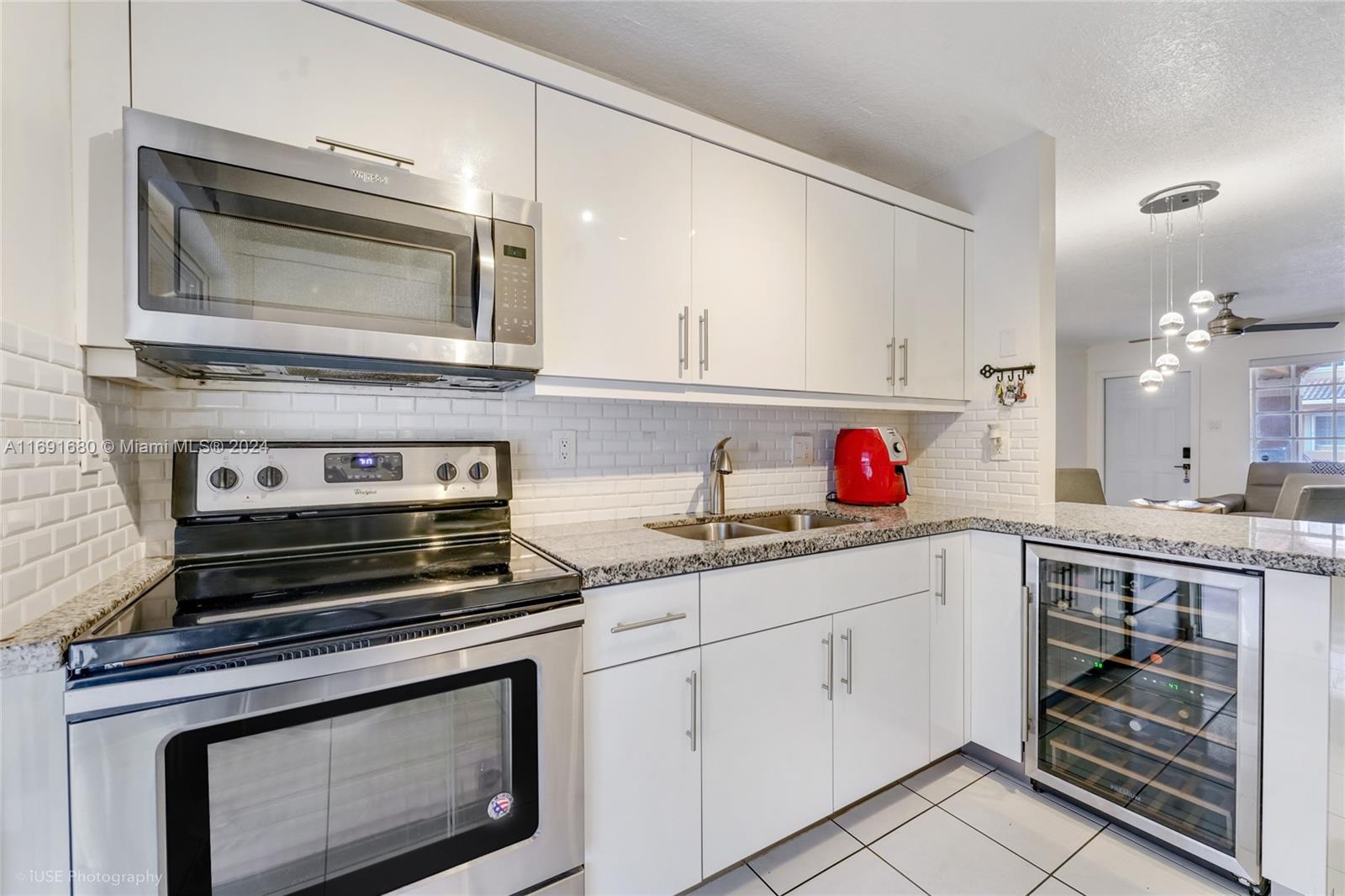 a kitchen with white cabinets and appliances