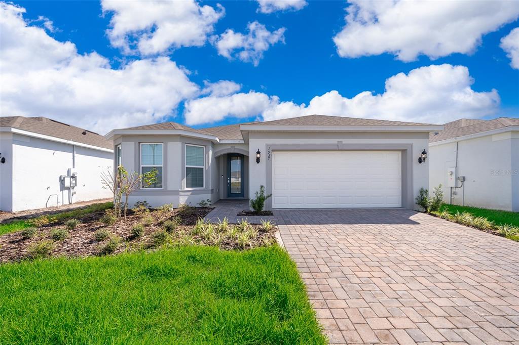 a front view of a house with a garden and yard