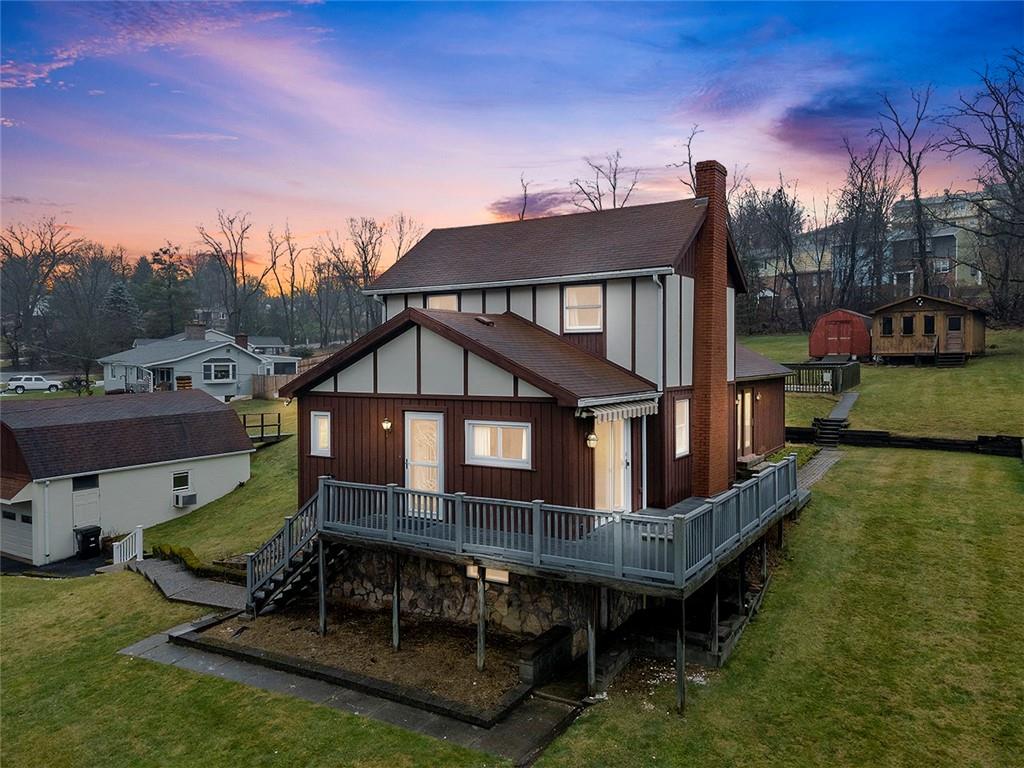 a view of a house with wooden deck front of house