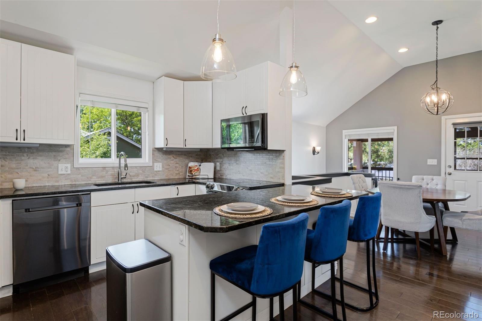 a kitchen with a stove a sink a dining table and chairs