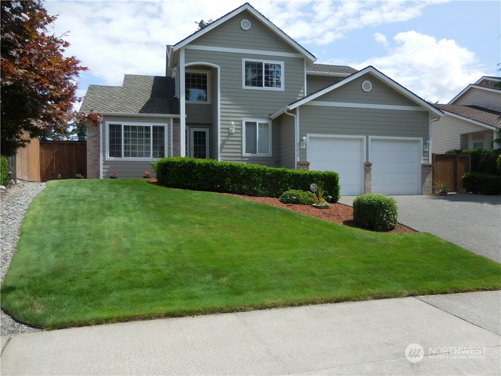 a front view of a house with a yard and garage