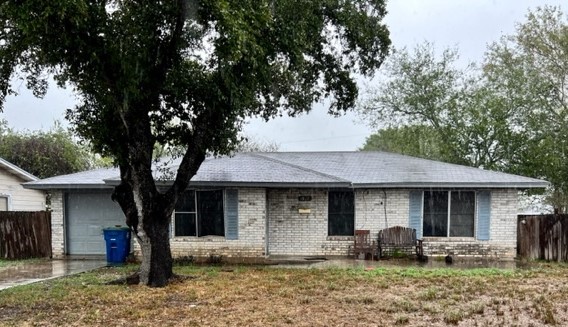 a front view of a house with garden and patio