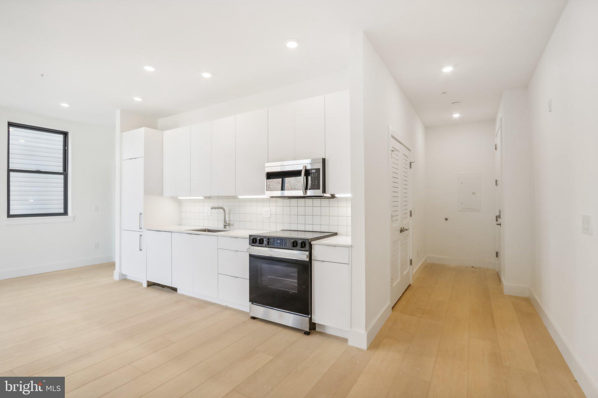 a kitchen with white cabinets and stainless steel appliances