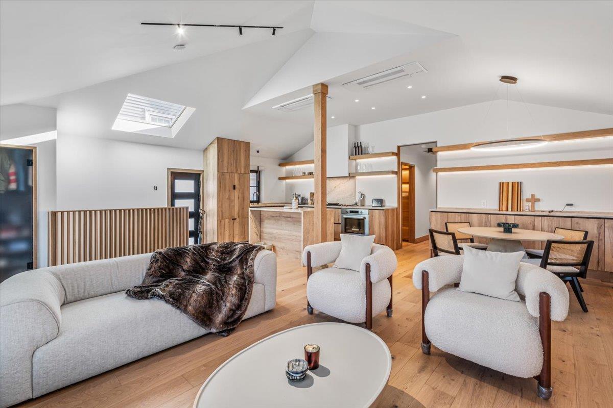 Living room with light wood-type flooring and vaulted ceiling