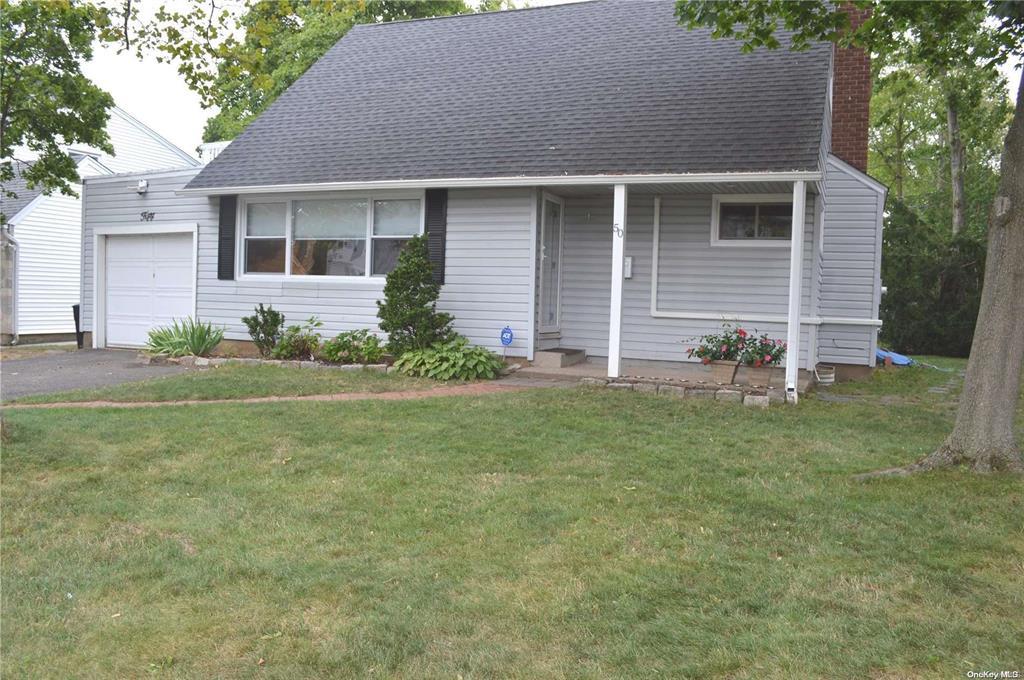 View of front of home with a front yard and a garage