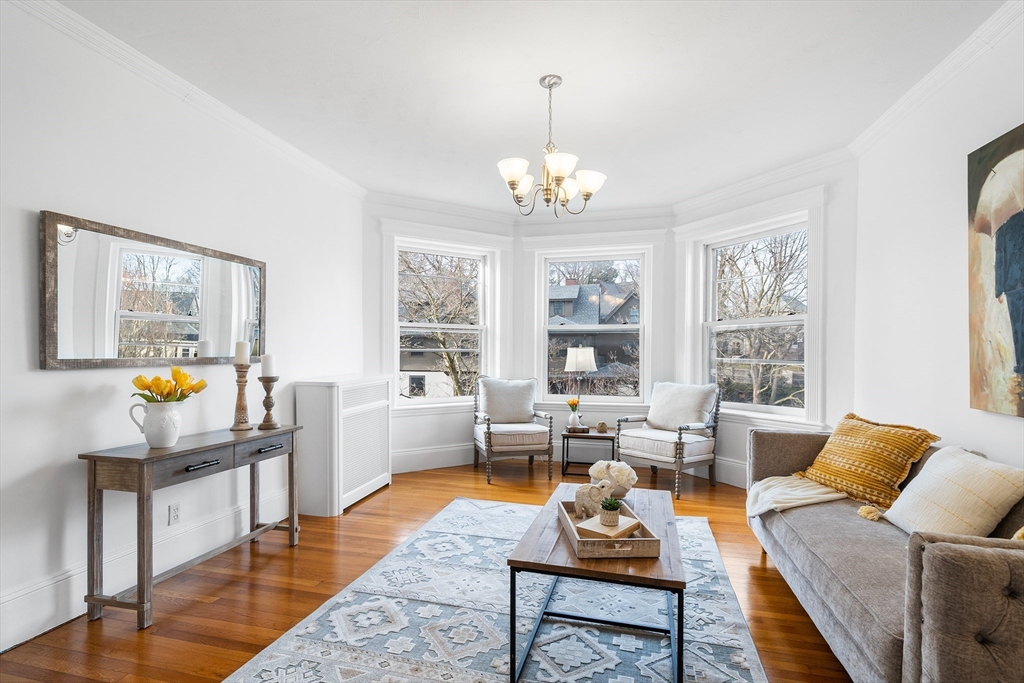 a living room with furniture a fireplace and a chandelier