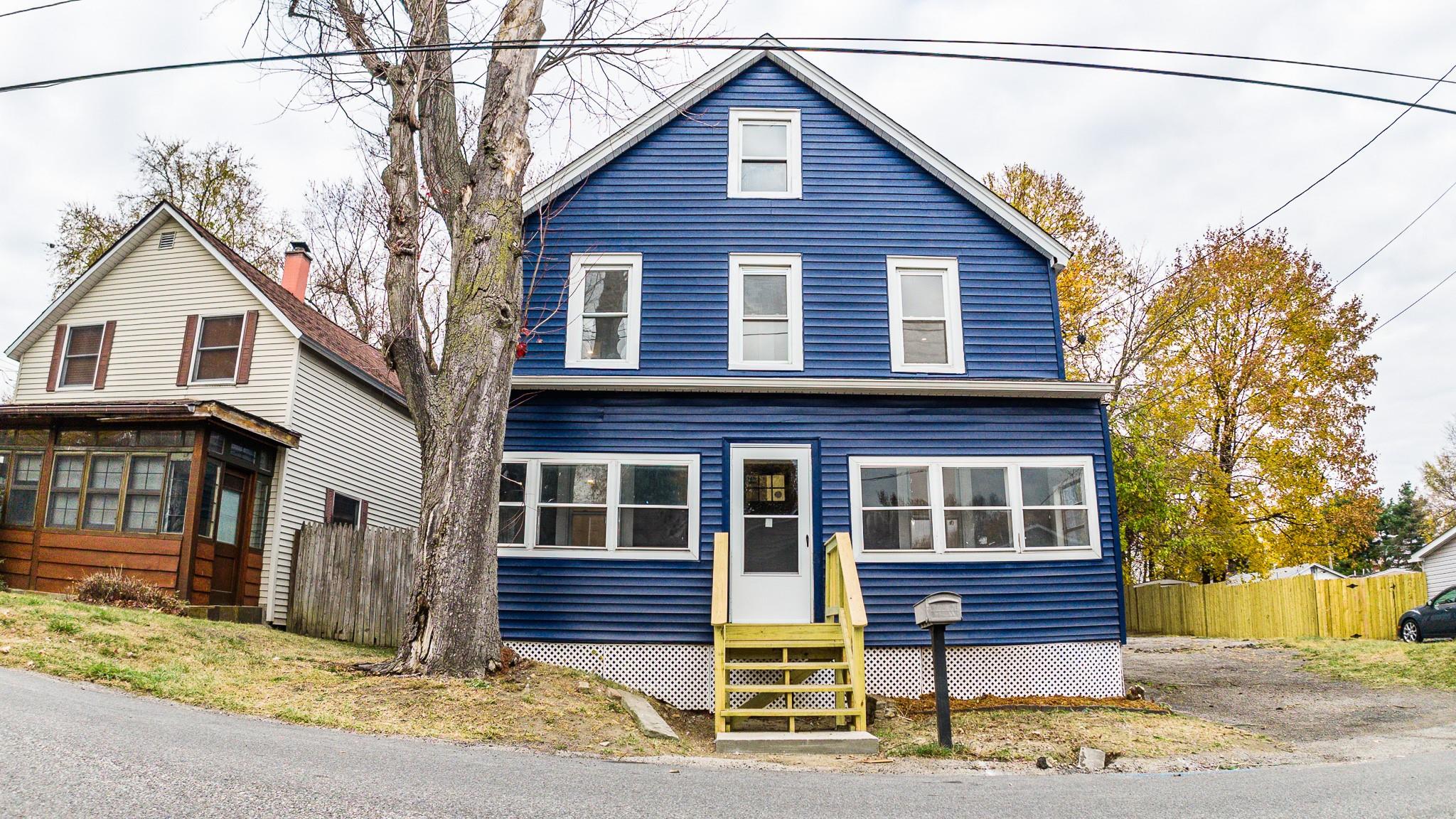 a front view of a house with a tree in it