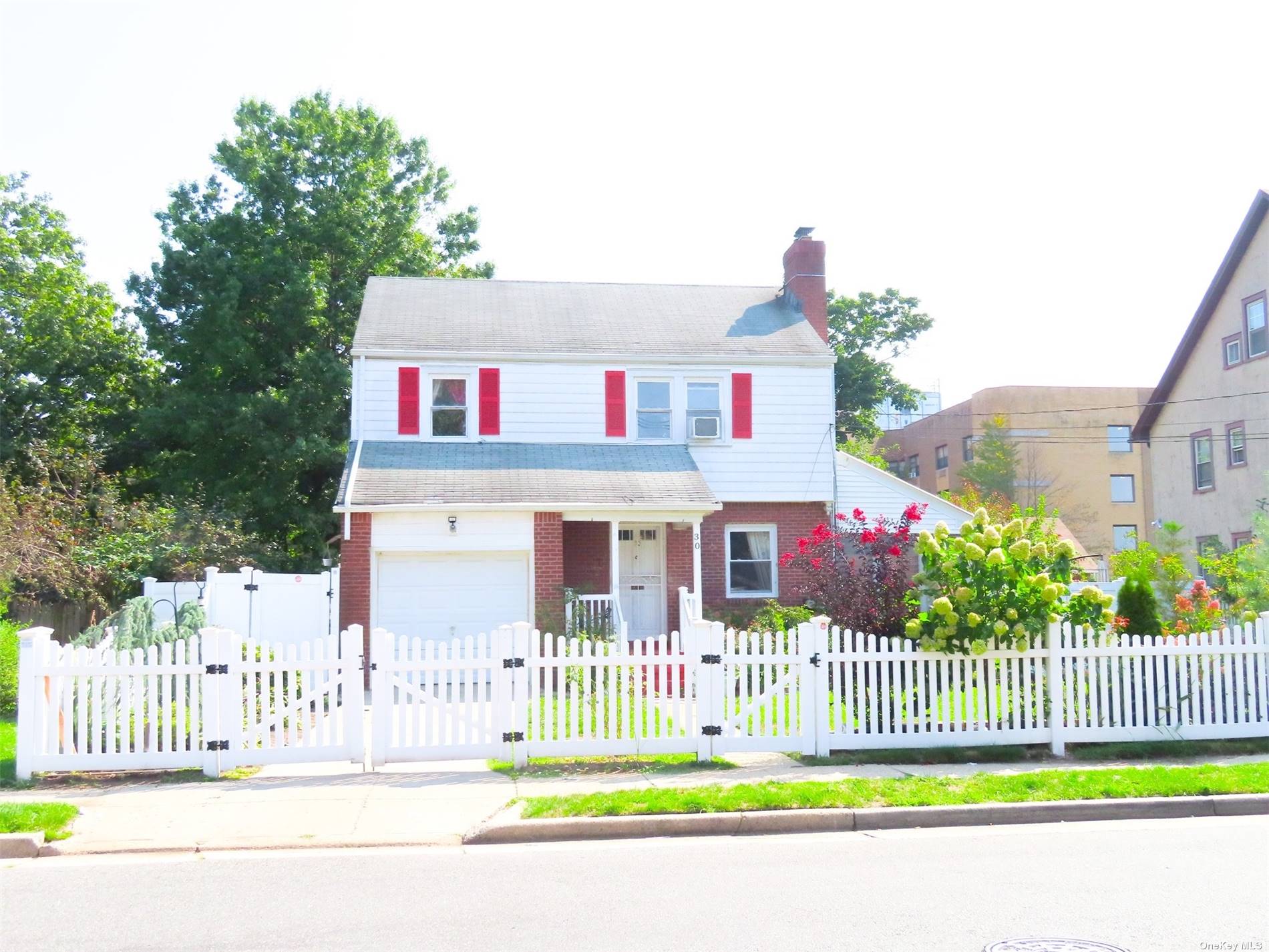 a front view of a house with a garden and plants