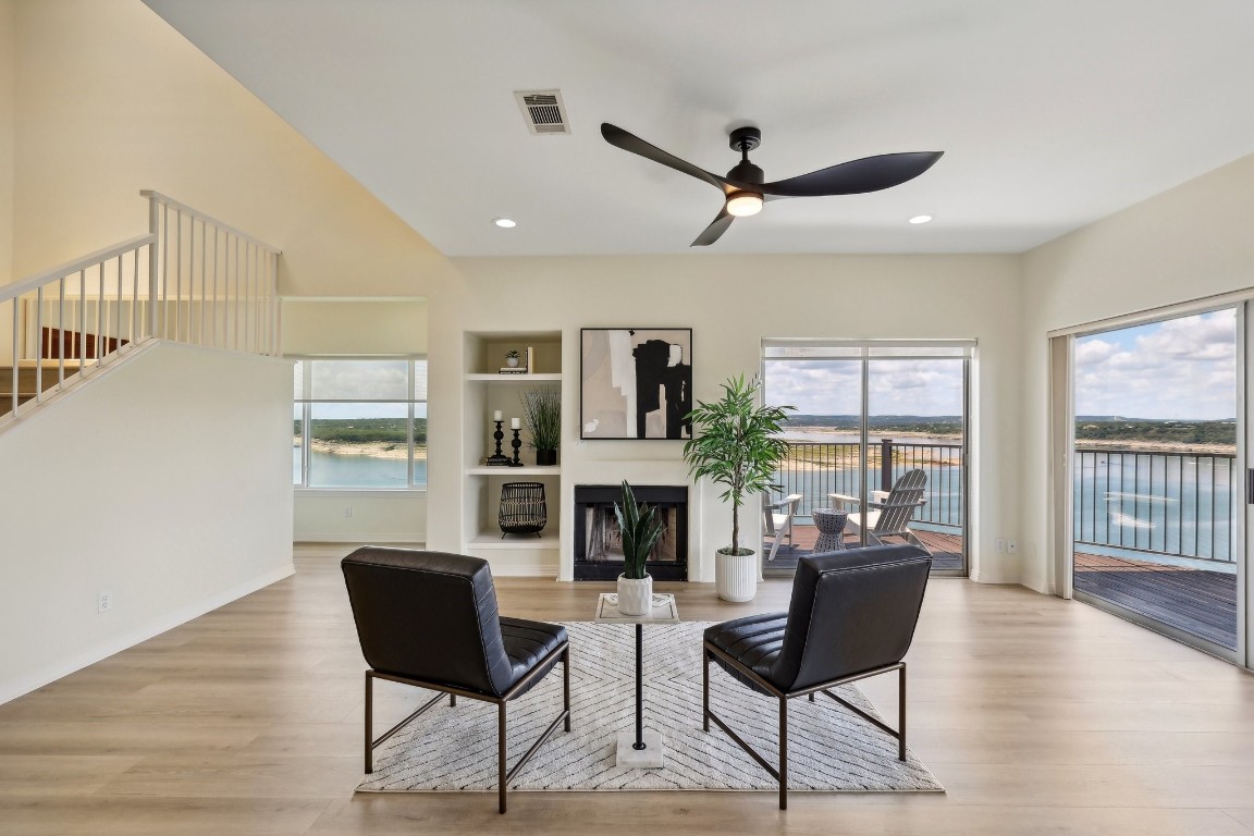 a living room with furniture a fireplace and a floor to ceiling window