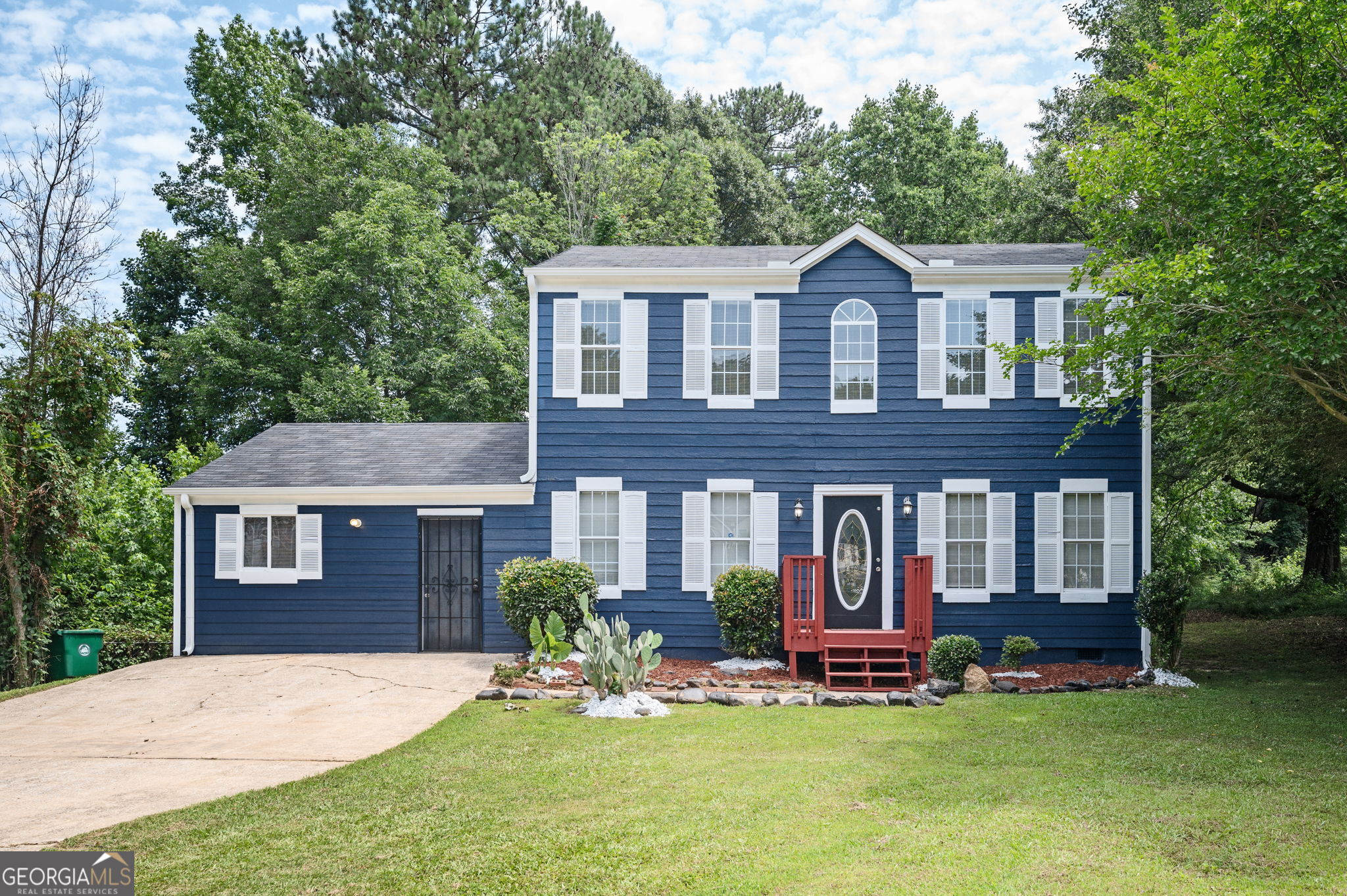 a front view of a house with a garden and yard