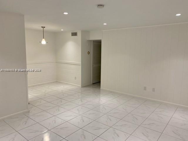 an empty room with white walls and tiles