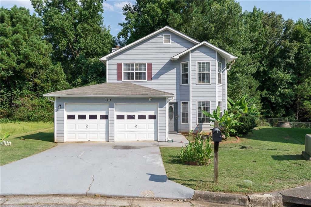 a front view of a house with a yard and garage