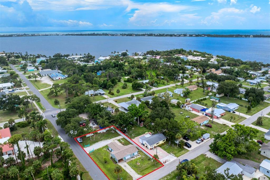 an aerial view of a city with lots of residential buildings ocean and mountain view in back