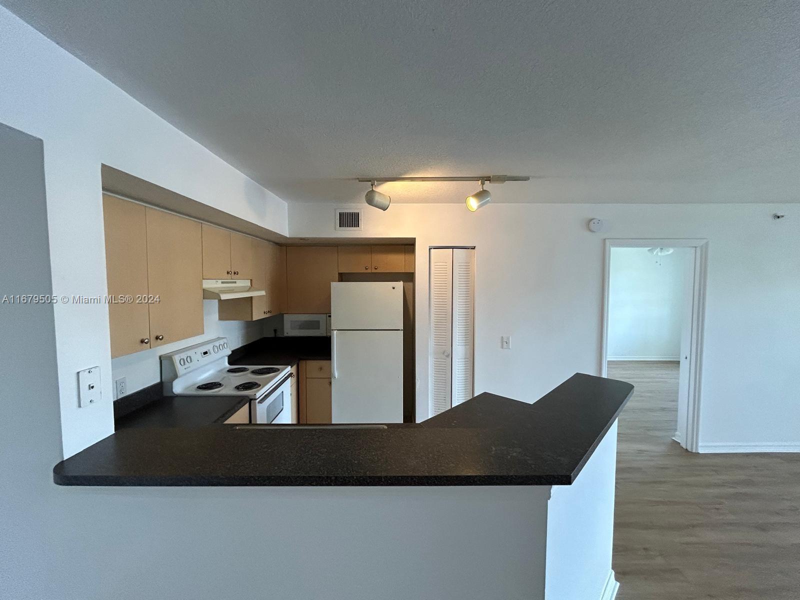 a kitchen with a refrigerator and a stove top oven