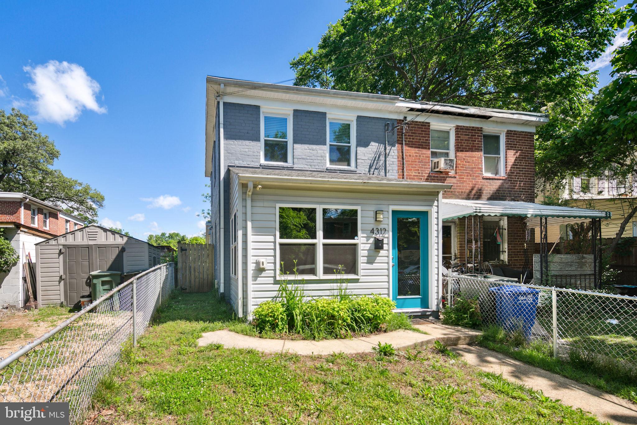 a front view of a house with a yard and potted plants