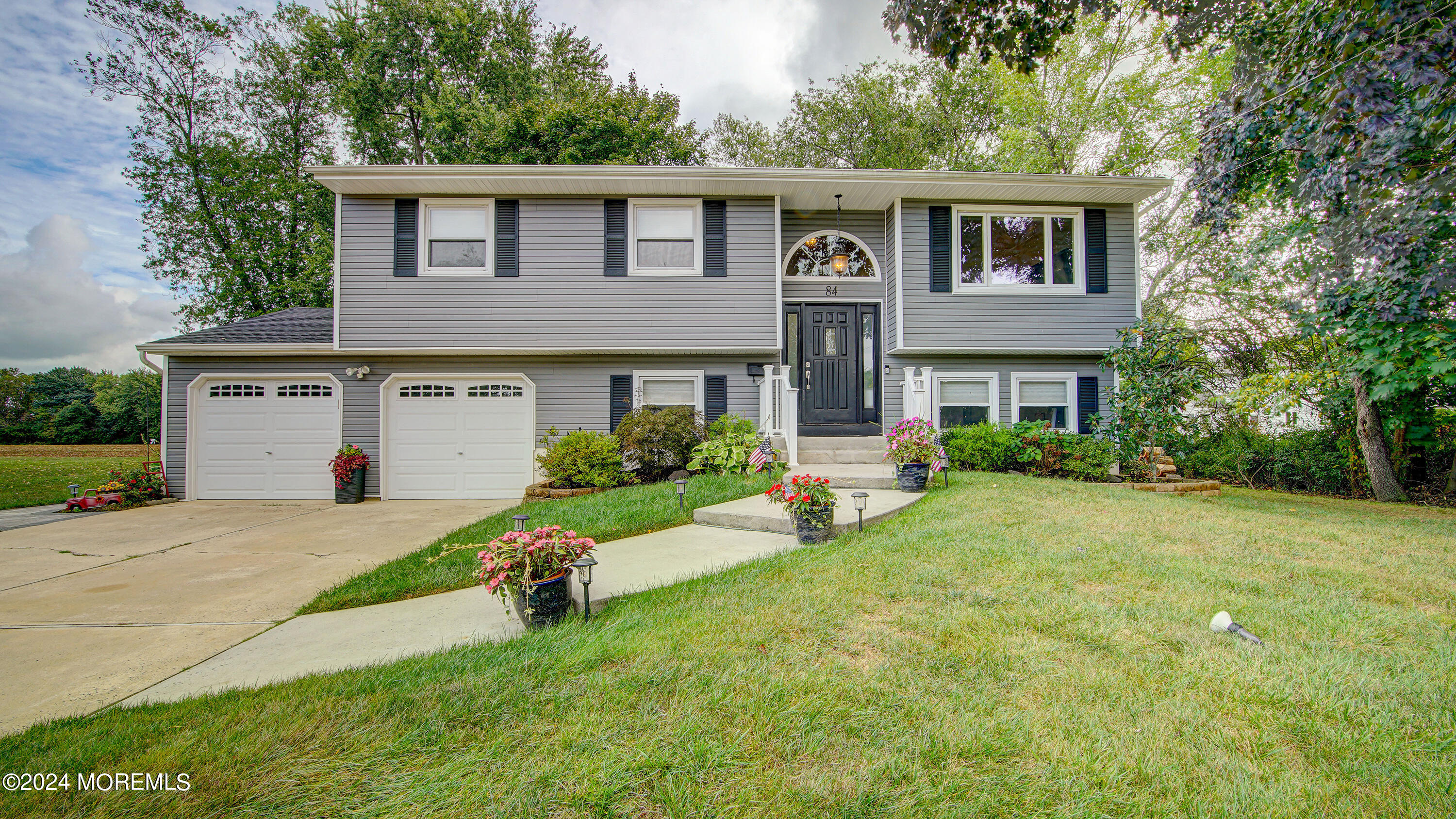 a front view of a house with a yard and trees