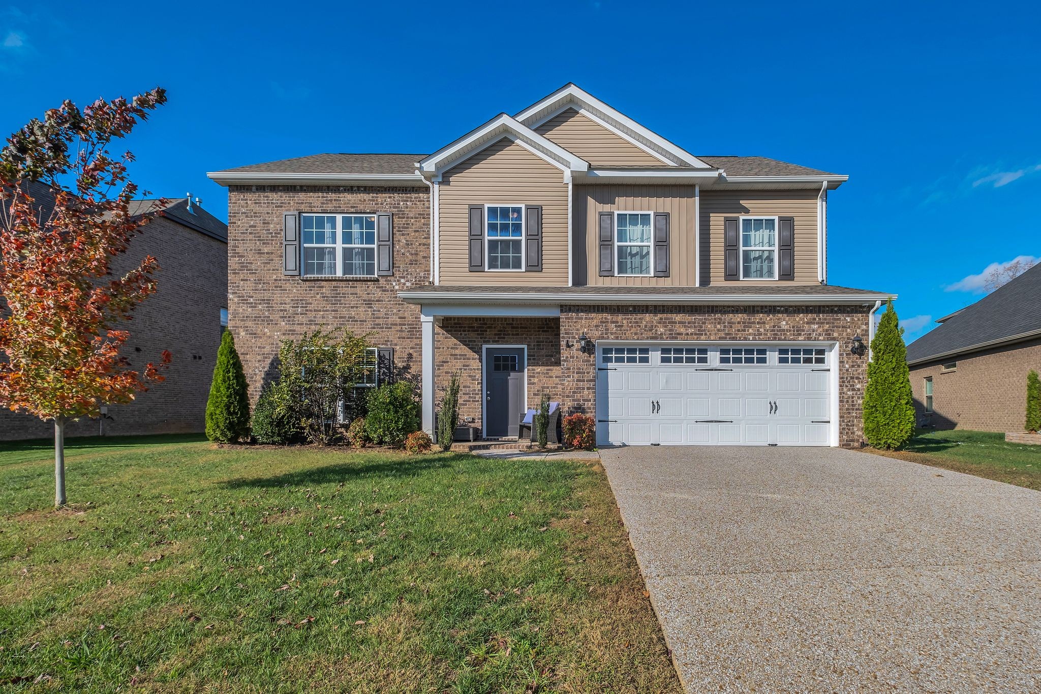 a front view of a house with a yard and garage