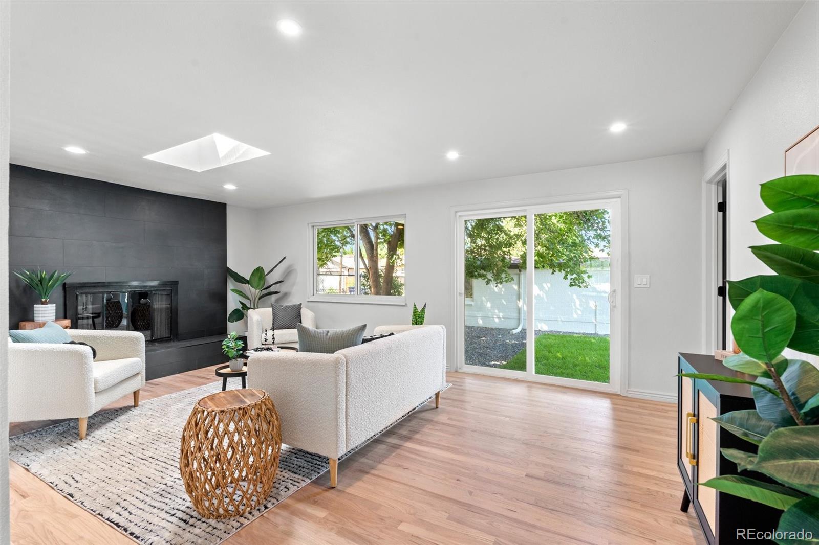 a living room with furniture a large window and a wooden floor