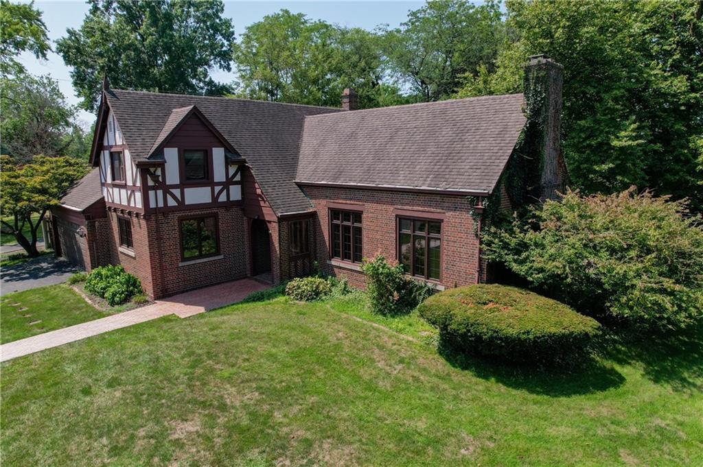 a aerial view of a house next to a big yard and large trees