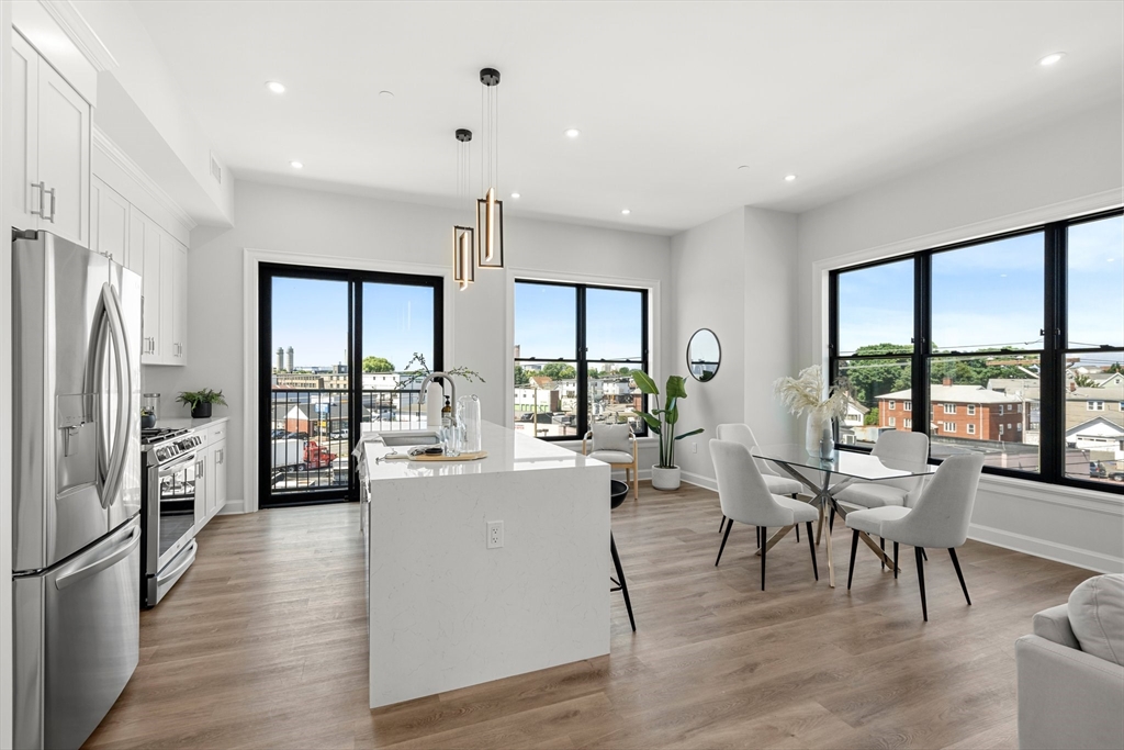 a living room with furniture wooden floor and large windows