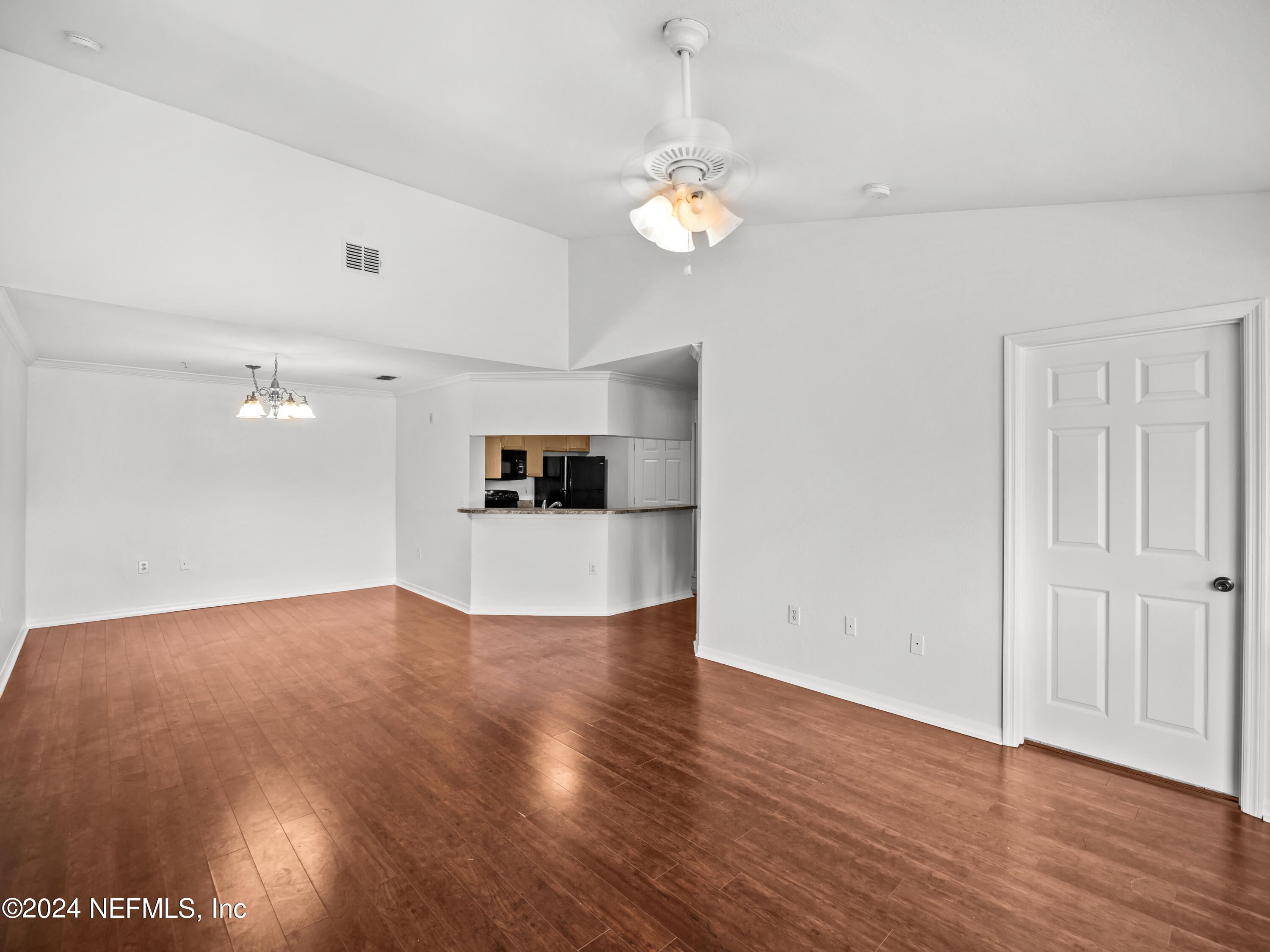 a view of empty room with wooden floor