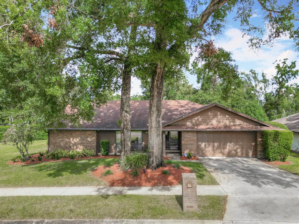 front view of house with a yard and potted plants