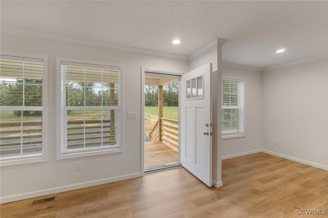 Doorway to outside with light hardwood / wood-styl