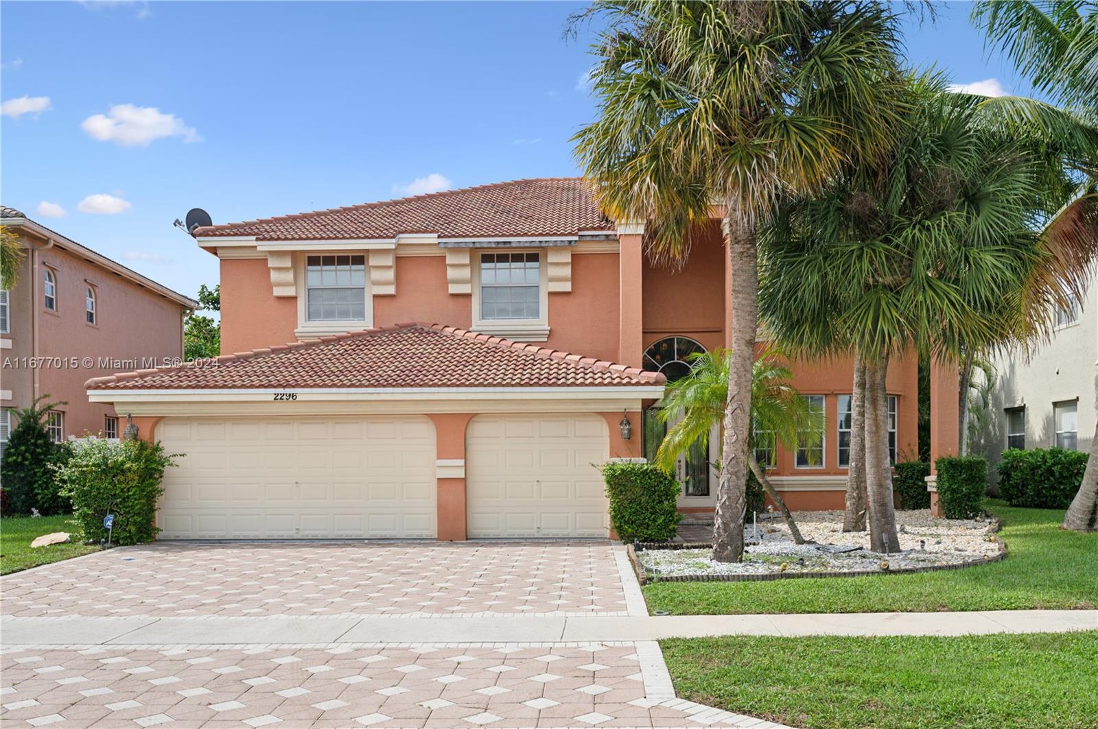 a front view of a house with a garden and palm trees