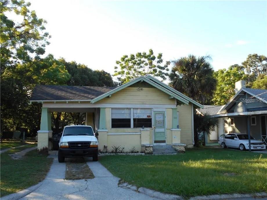 a front view of a house with a garden and trees