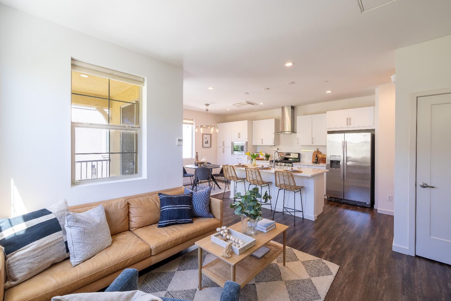 a living room with furniture and a window with kitchen view