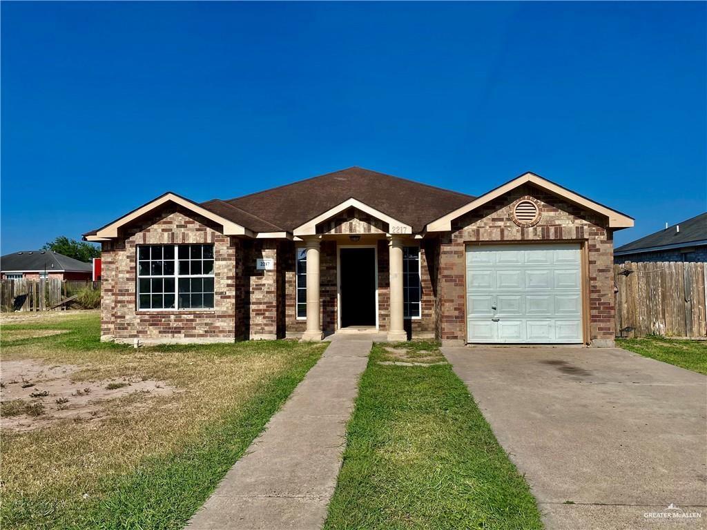 Ranch-style house featuring a front lawn and a garage