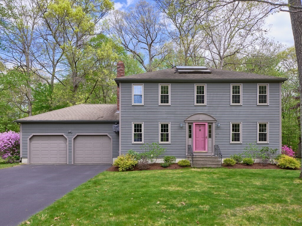 a front view of a house with a garden and yard