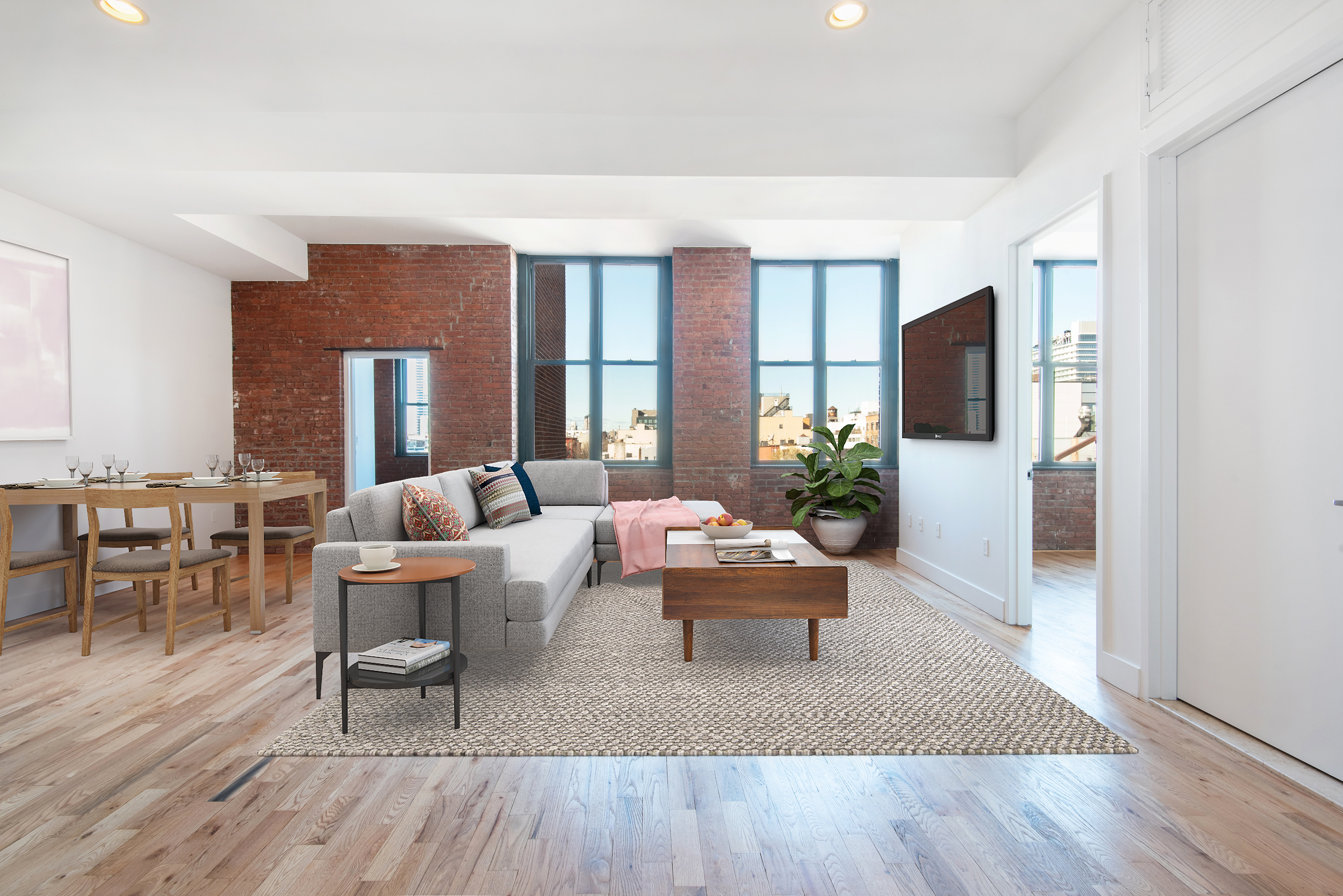 a living room with furniture a large window and wooden floor