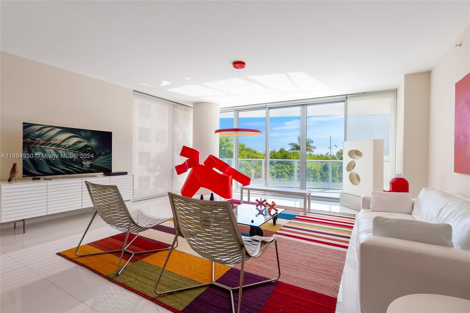 a living room with furniture a flat screen tv and a large window