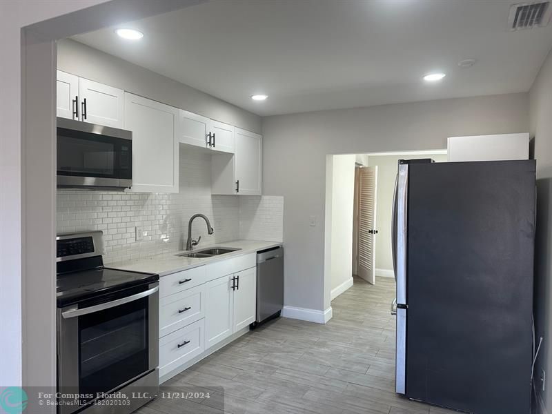 a kitchen with stainless steel appliances a stove sink and refrigerator