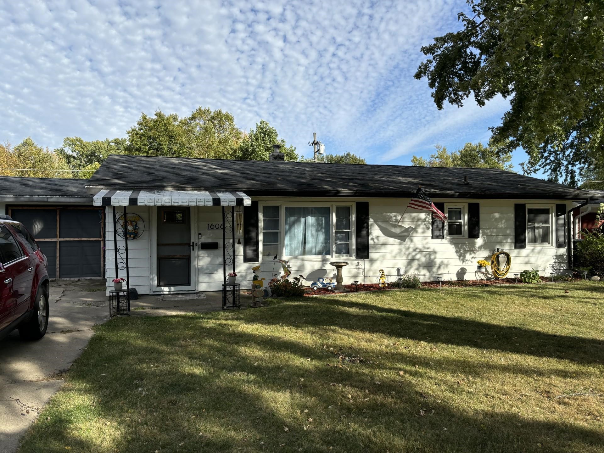 a front view of a house with swimming pool and porch with furniture