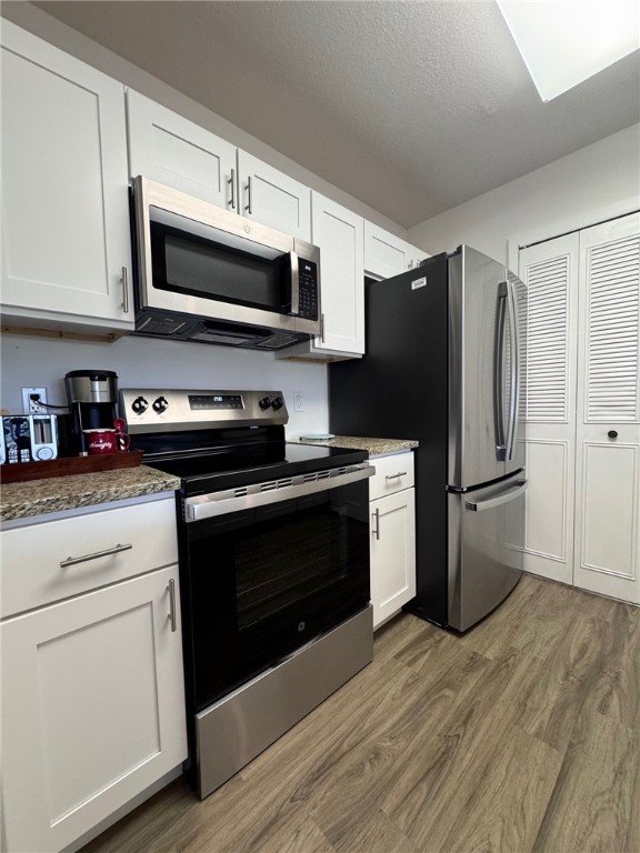 a kitchen with stainless steel appliances a refrigerator stove and microwave