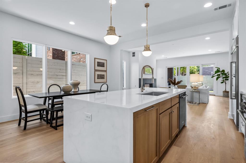 a large kitchen with lots of counter space a sink appliances and living room view