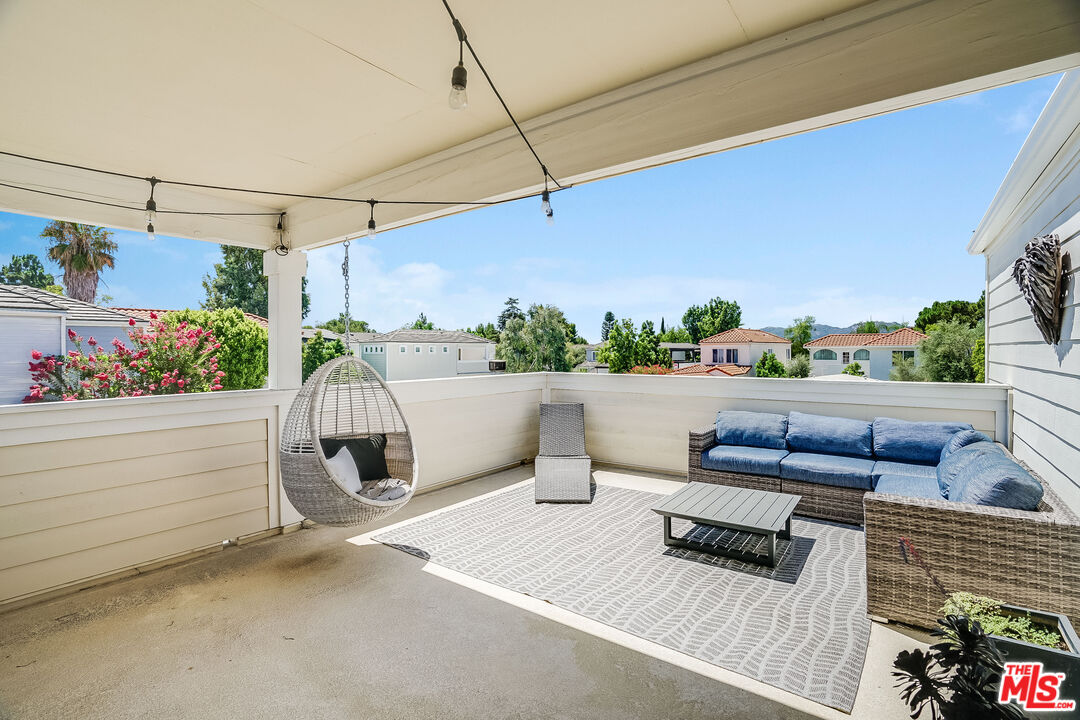 a roof deck with a couch and potted plants