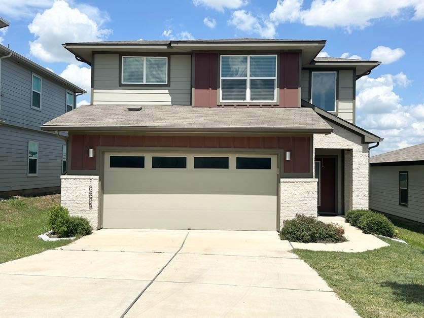 a front view of a house with a yard and garage