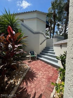 a view of a house with a small yard and potted plants