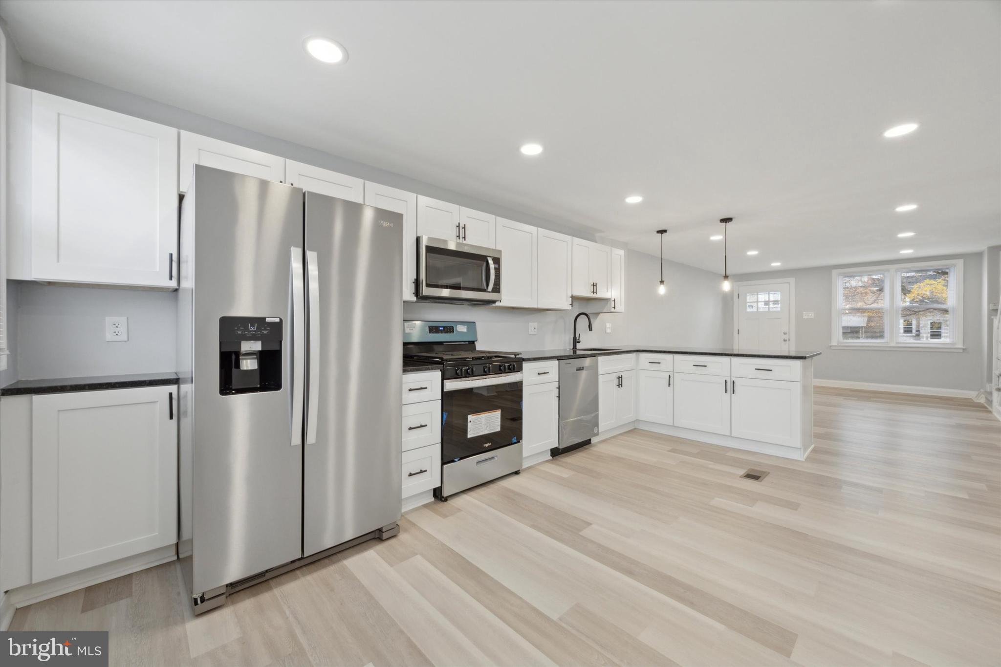 a kitchen with stainless steel appliances a refrigerator sink and microwave