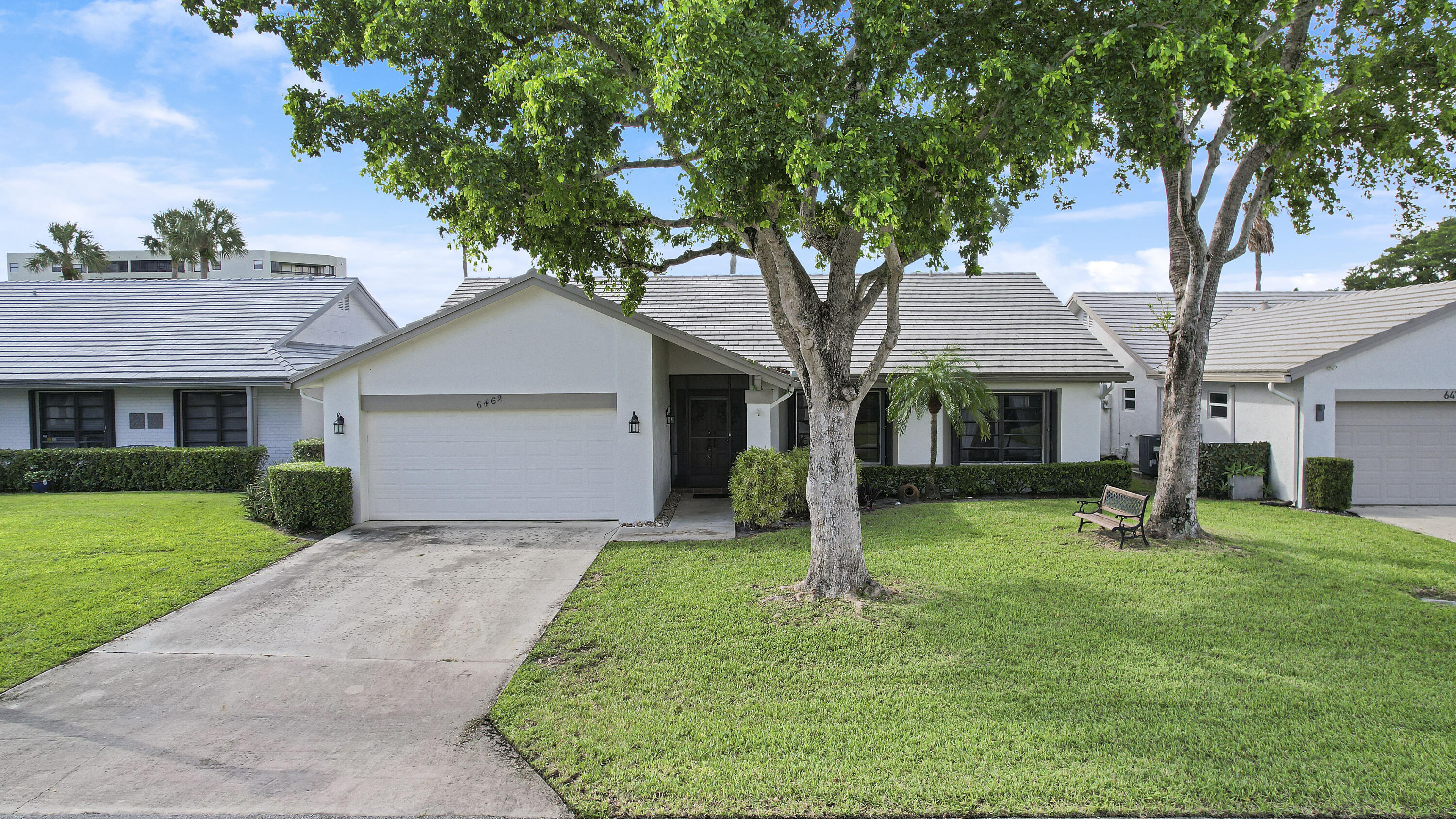 a front view of a house with a yard and trees