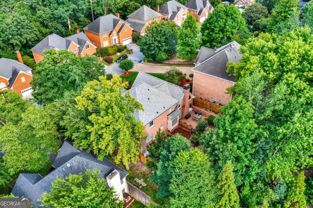 an aerial view of a house with a yard and trees