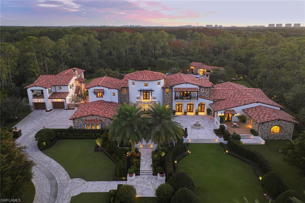 an aerial view of a house with a garden and lake view