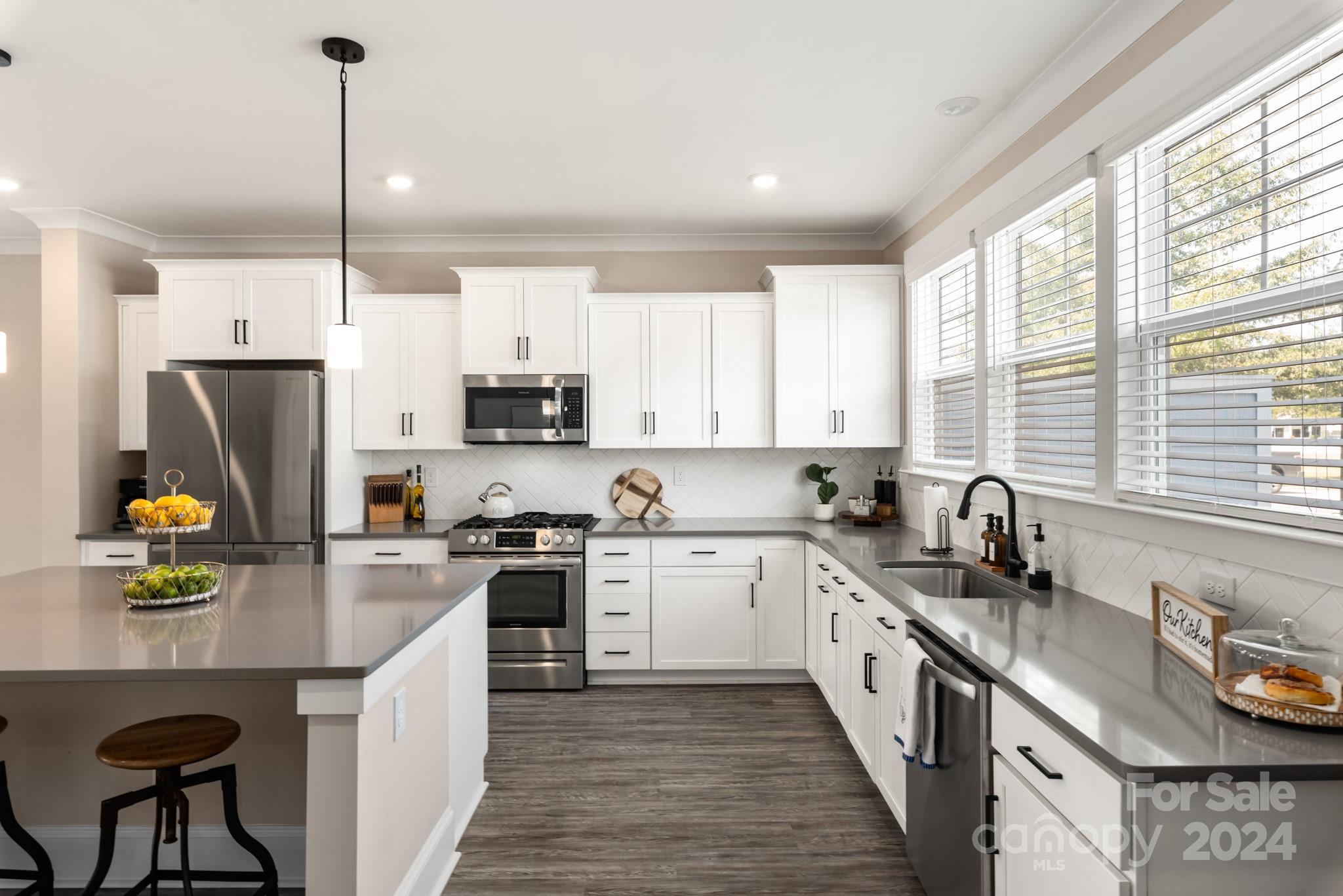 a kitchen with stainless steel appliances granite countertop a sink a stove and refrigerator