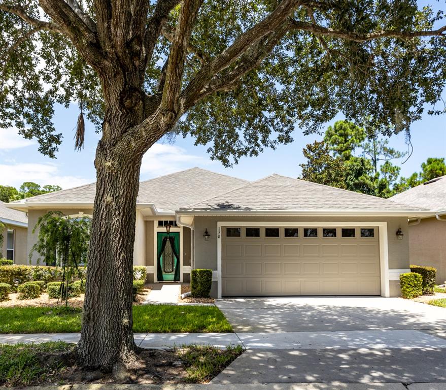 a front view of a house with a garden and yard